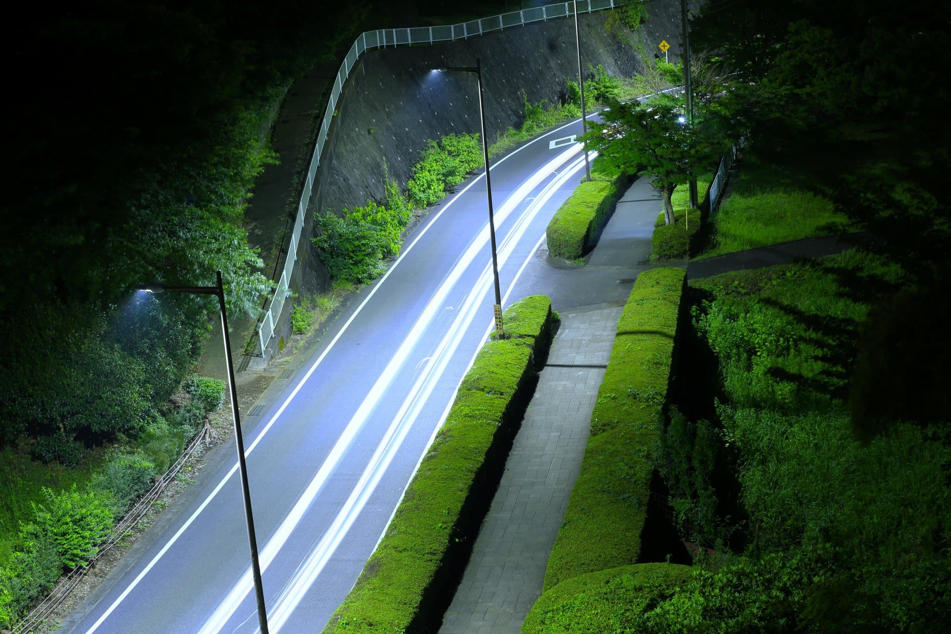 夜の峠道を照らすヘッドライト
